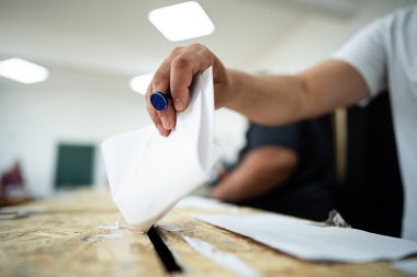 Seçimler sırasında sandıkta oy kullanırken bir kişi sandığa oy veriyor.