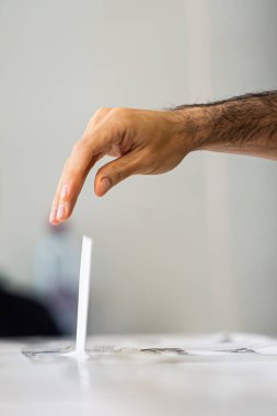 Seçimler sırasında sandıkta oy kullanırken bir kişi sandığa oy veriyor.