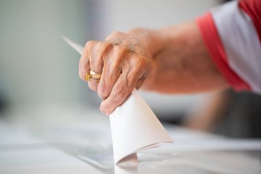 Seçimler sırasında sandıkta oy kullanırken bir kişi sandığa oy veriyor.