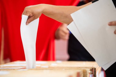 Seçimler sırasında sandıkta oy kullanırken bir kişi sandığa oy veriyor.