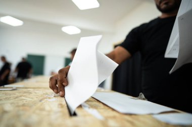 Seçimler sırasında sandıkta oy kullanırken bir kişi sandığa oy veriyor.