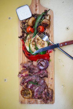 Tahtada ızgara sebzeli az pişmiş biftek..