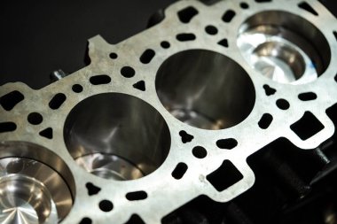 Dört silindirli açık bir benzin motorunun yakın çekim görüntüsü.