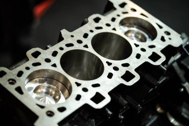 Dört silindirli açık bir benzin motorunun yakın çekim görüntüsü.