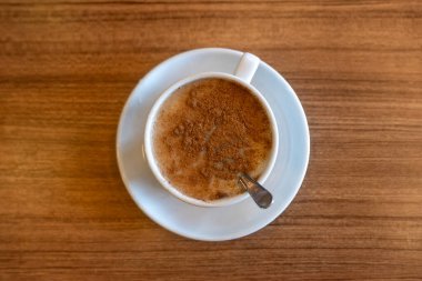 Kafedeki ahşap masada bir fincan salep.