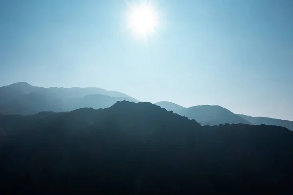 Layers of blue mountain silhouette with sunny blue sky. High quality photo