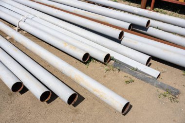 Kumlu zemine yığılmış borular. Yüksek kalite fotoğraf