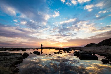 Gün batımında sahilde bir balıkçının silueti. Yüksek kalite fotoğraf
