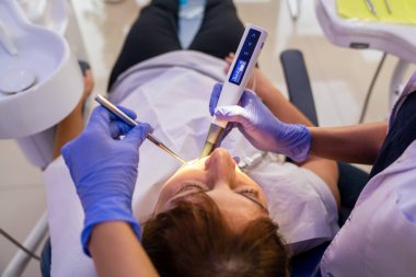 Kadın dişçi kliniğinde diş tedavisi görüyor..