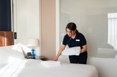 Hizmetçi odayı temizler, çarşafları ve havluları değiştirir. Yüksek kalite fotoğraf