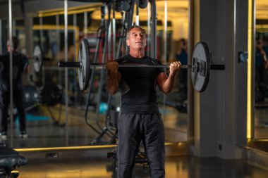 Orta yaşlı bir adam spor salonunda ağırlık kaldırıyor. Yüksek kalite fotoğraf