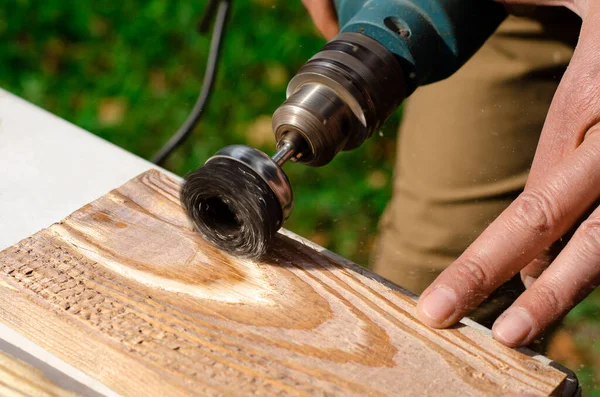 男性の手は 木材の一部を立っ金属ディスクとブラッシングマシン電気回転を保持しています — ストック写真