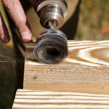 Ahşap işleme. Elektrikli aleti olan bir adamın elleri.