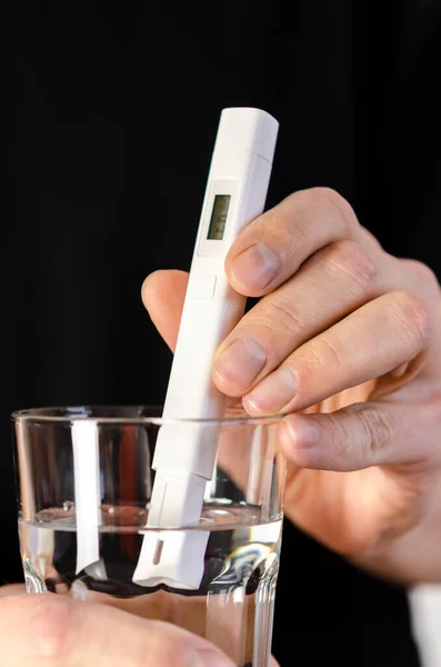Measuring the quality of drinking water. Water Quality Tester in a Glass of Water