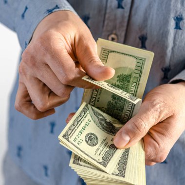 A man hands over a thick wad of dollars. bribe