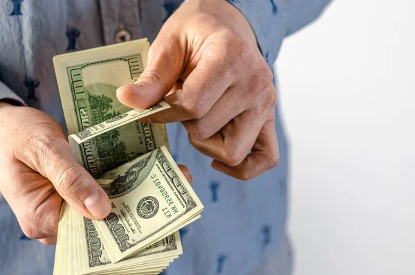 A man hands over a thick wad of dollars. bribe