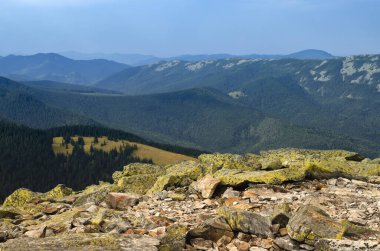 Turist memnuniyeti. Yürüyüş. Sisteki yüksek sıradağların zeminine karşı yeşil oklarla kaplanmış devasa taşlar.