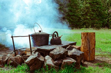 Tencere dibin kara seninki benden kara. Kamp ateşinde yemek pişirmek..
