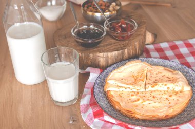 Yuvarlak bir tabakta reçelin yanında duran tatlı yuvarlak krepler. Gözleme..