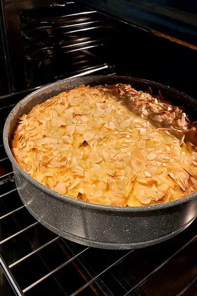 Golden apple pie with almonds in the oven. Homemade cakes.