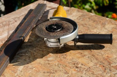 Üzerinde metal disk olan bir öğütücü masanın üzerinde yatıyor. Ağır sanayi işçisi.