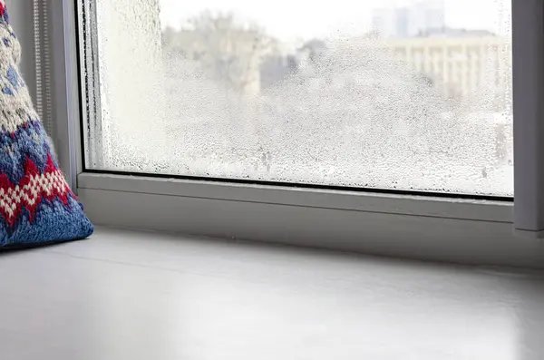Drops of condensation on glass in winter. Metal-plastic window