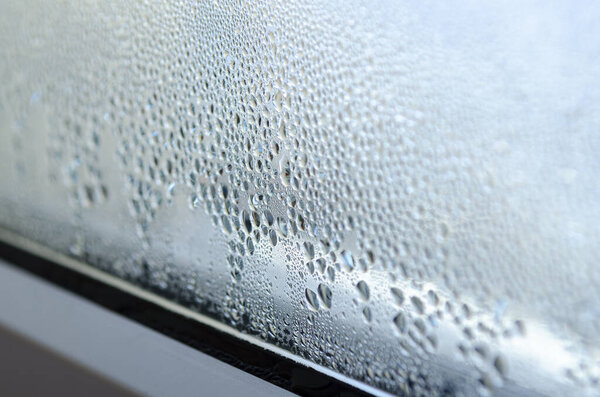 Greenhouse effect. Drops of condensation on the glass of a metal-plastic window.