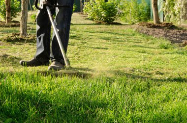 Bahçede bahar çim biçme. Çim biçen adam