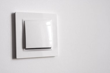 Beyaz güç anahtarı beyaz duvarda, metin için boşluk var.