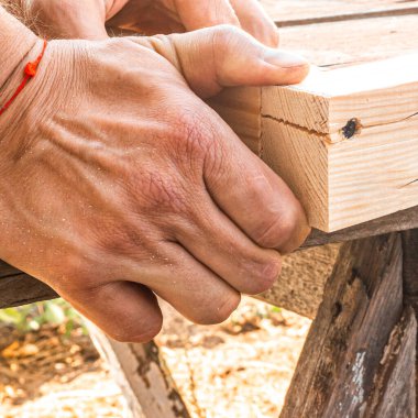 Hands close-up. Repair of wooden products. clipart