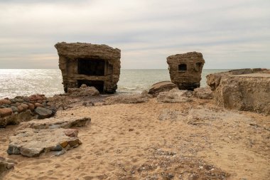 Deniz kıyısındaki terk edilmiş binalar. Savaş, Baltık denizinde çürüyen bir harabe. Liepaja, Letonya 'daki eski kale sığınakları..