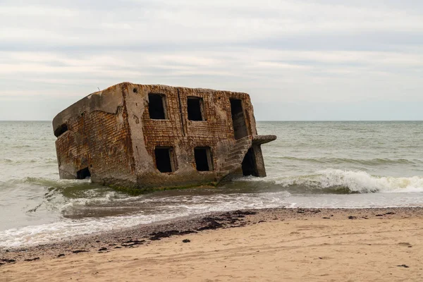 Stock image Abandoned buildings on the seashore in the water. War ruins decomposing in the Baltic sea. Former fort bunkers in Liepaja, Latvia.