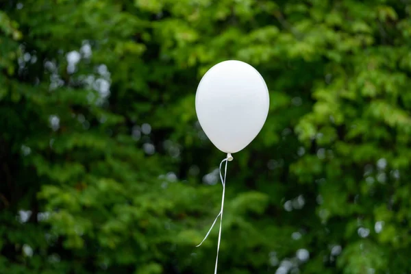 White balloon floating in the air. Helium balloon in the nature.