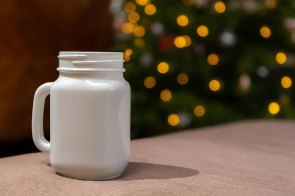 Biały Kubek Świąteczny Leżący Stole Zamazane Światła Tle Kubek Xmas — Zdjęcie stockowe