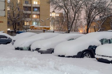 Araba kalın kar tabakasıyla kaplı. Yol kenarına park etmiş kar fırtınası sonrası otomobil..