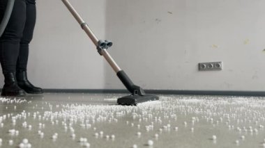 Ofis zeminini süpüren işçinin düşük açılı görüntüsü. Koridoru temizlemek için profesyonel temizleyici vakum makinesi. 