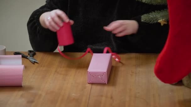 Жінка Обмотує Подарунок Роздягненому Папері Червоною Стрічкою Руки Упаковують Коробку — стокове відео