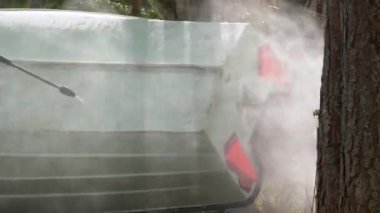 Ellerinizi kapayın, eldivenlerle sıkıştırılmış su püskürterek dışarıdaki tekne yüzeyinin pisliğini temizleyin. Balıkçı teknesi bakımı. 