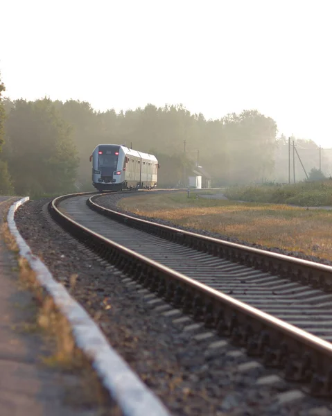 列車は霧の朝に駅を出る 鉄道駅 カラフルな青空 木々や緑の芝生 夏には黄色の太陽の光と産業風景 鉄道の交差点 重工業 — ストック写真
