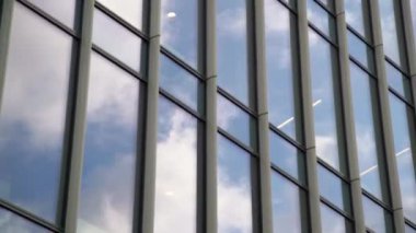 Gökdelen pencerelerindeki bulut yansımalarının dinamik görüntüsü. Finansal bölgenin modern zaman aşımı 