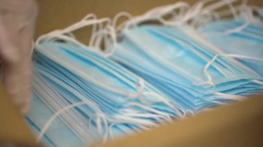 Eldiven takan ve fabrikada tıbbi maske takan çalışanların ellerini kapatın.. 