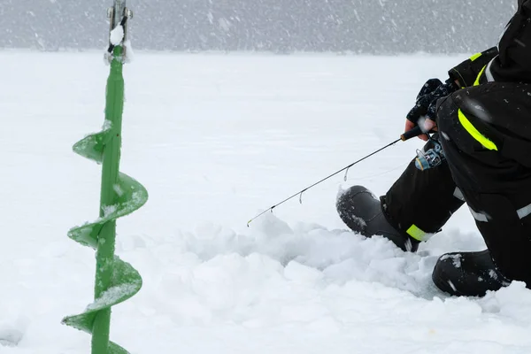 Winterangeln Auf Eis Mann Wirft Köder Ein Eisloch Entspannung Freier Stockfoto