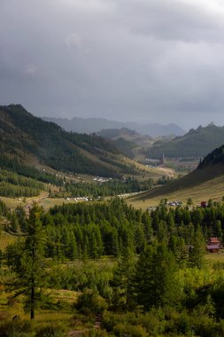 Terelj Ulusal Parkı manzarası, Moğolistan 'daki dağ sırtı. Arka planda dramatik gökyüzü olan vadinin genel görünümü.