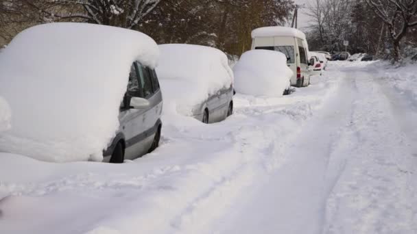 暴风雨后汽车在厚厚的积雪下行驶 埋在冰下的车没人 — 图库视频影像