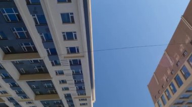 Güneşli bir günde şehirde apartman blokları. Kalabalık bir bölgede yoğun bir yolda araba sürmek 