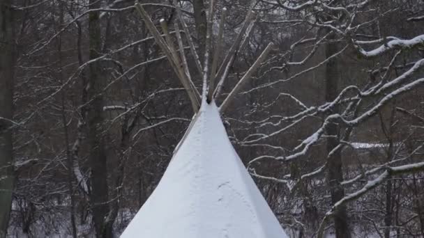 ティピテントの雪の森では 川の横に覆われた 冬は屋外で魅力的なキャンプ場 — ストック動画