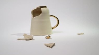 Broken tea cup isolated on white background. Cracked coffee mug and fragile ceramic pieces 