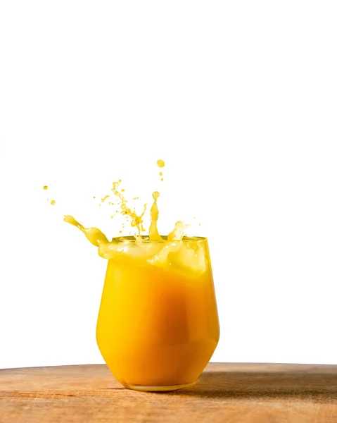 Ein Glas Frischer Orangensaft Plätschert Auf Dem Holztisch Vor Weißem — Stockfoto