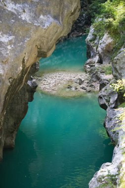 Valcellina 'nın kalbinde, parlak yeşil bir su havuzu ziyaretçileri Barcis' in güneşli havzasına davet eder.