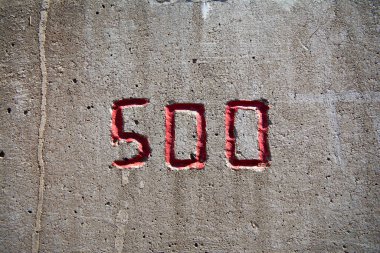 the number 500 carved into a concrete wall in red